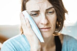 woman putting icebag on face after wisdom tooth removal